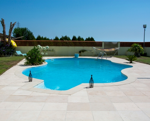 Manutenção da piscina em dias de calor com água cristalina e piso em pedra