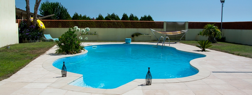 Manutenção da piscina em dias de calor com água cristalina e piso em pedra