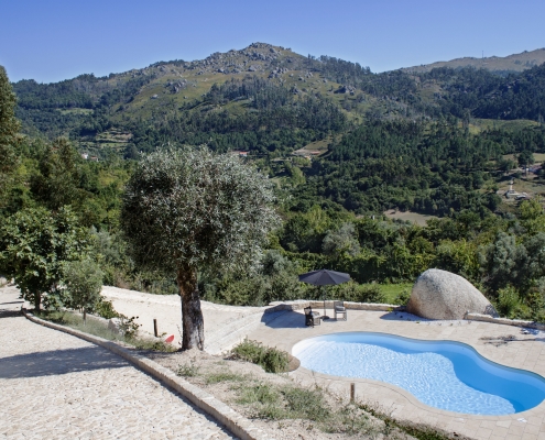 Poupar água na piscina numa propriedade rodeada de serra e vegetação